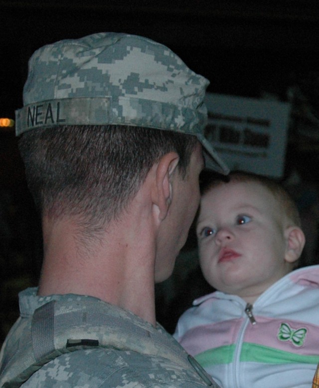 Ten-month-old Grace Neal looks into her father's eyes, Sgt. Russell Neal, an apache mechanic with 4th Battalion, 227th Aviation Regiment, 1st Air Cavalry Brigade, 1st Cavalry Division, for the first time since she was 8-weeks old at a homecoming...