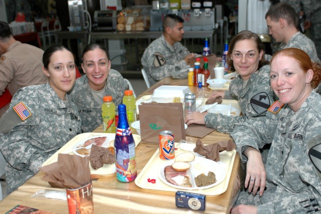 (Left to right) Spcs. Christina Padilla, from Los Angeles; Dawn Murgia, of Waldorf, Md.; Lynn Hansford, from Oldtown, Md.; and Mindy Saindon, of Derby, Kan., ham it up at the Thanksgiving meal at the Command Sgt. Maj. Cooke Dining Facility Nov. 22 at...