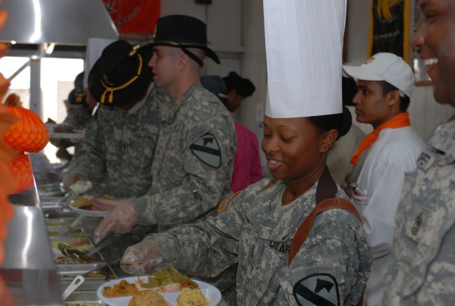 Canton, Miss., native Capt. Katina Sutton, commander of the Command Post Detachment, Division Special Troops Battalion, 1st Cavalry Division, serves Thanksgiving dinner to Soldiers in the Pegasus Dining Facility at Camp Liberty in western Baghdad,...