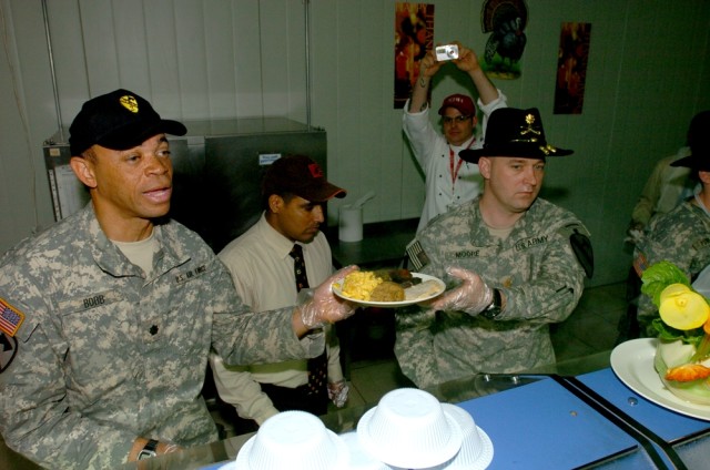 Air Force Lt. Col. Justin Bobb (left), 2nd Brigade Combat Team's electronic warfare officer, and Maj. Lance Moore, the Black Jack Brigade's operations officer, serve the troops at the Black Jack Bistro Dining Facility on Forward Operating Base Prospe...