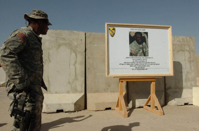 Staff Sgt. Mario Whitaker, non-commissioned officer in charge of the brigade commander's Personal Security Detachment, 3rd Brigade Combat Team, 1st Cavalry Division, looks at the memorial picture of Staff Sgt. Donnie Dixon, a good friend and...