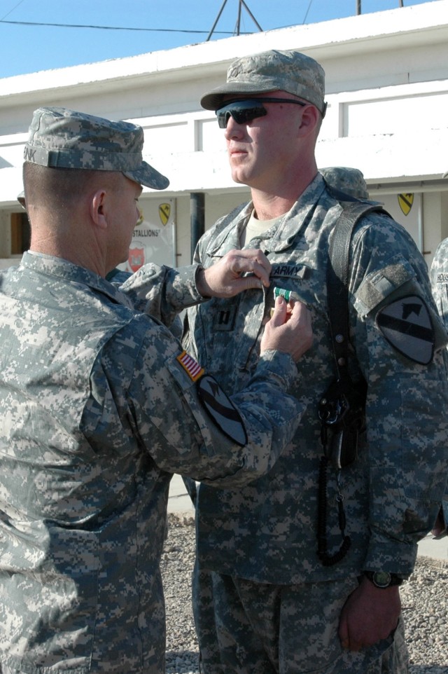 Col. Paul E. Funk II, commander, 1st "Ironhorse" Brigade Combat Team, 1st Cavalry Division presents the Army Commendation Medal with "V" device to Highlands Ranch, Colo. native Capt. Corey Wallace, executive officer of Company D, 2nd "Stallion" Batta...