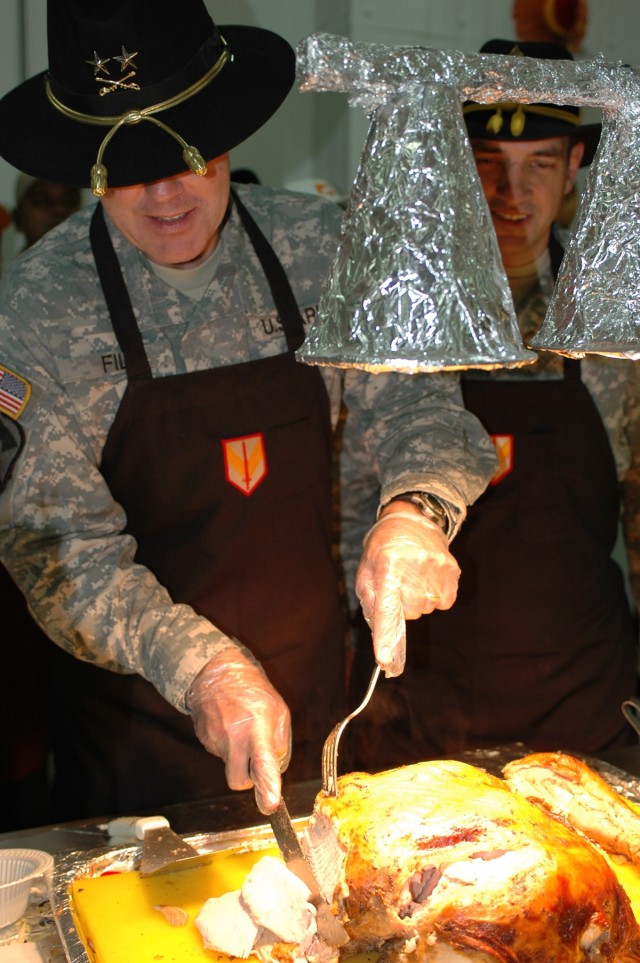 Maj. Gen. Joseph Fil, Jr. (left), 1st Cavalry Division and Multi-National Division - Baghdad commanding general and Command Sgt. Maj. Philip Johndrow, the senior noncommissioned officer with the 1st Cav. Div. and MND-B, carve a turkey at a dining...