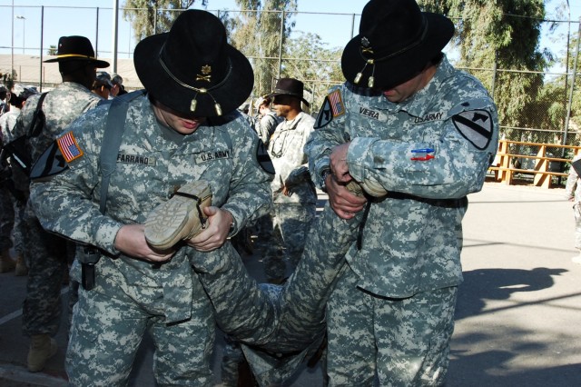 Maj. Dale Farrand (left), the executive officer for the 15th Brigade Support Battalion, 2nd Brigade Combat Team, 1st Cavalry Division, and the 15th BSB commander, Lt. Col. Jeffrey Vieira, strap on a pair of gold combat spurs to the boots of one of...