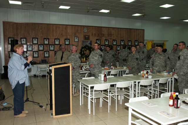 Soldiers from the 2nd Brigade Combat Team, 1st Cavalry Division join Betsy Brown, the founder of Heartsong Ministries, a non-profit organization in Texas, for a rendition of "God Bless America" during a prayer luncheon at Forward Operating Base Prosp...