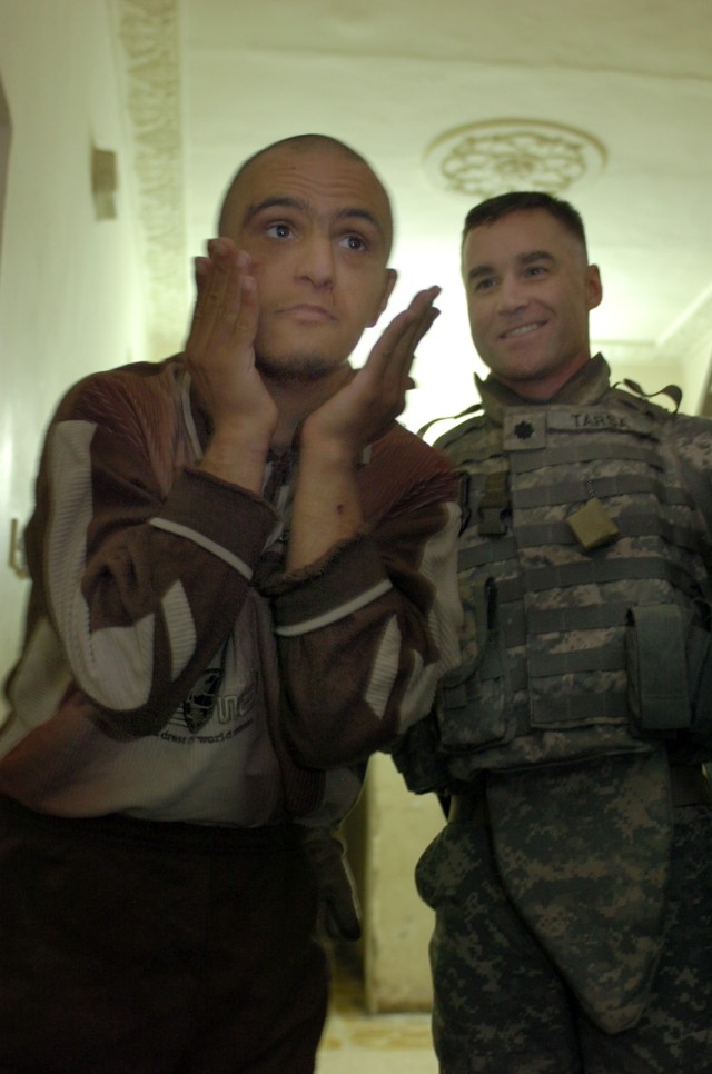 Lt. Col. Michael Tarsa, commander 3rd Battalion, 82nd Field Artillery Regiment, 2nd Brigade Combat Team, 1st Cavalry Division, watches one of the residents of the Dina Institute for the mentally handicapped Dec. 1. Tarsa and troops from the "Red...