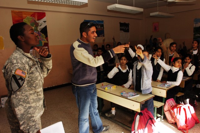 Dr. Z, an Iraqi general practitioner, points to a student to answer a question while Sgt. Danielle Stephens, a preventive medicine specialist with Co. C, 15th BSB, 2nd BCT, 1st Cav. Div. looks on during a presentation on health awareness at the Al...