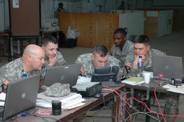 The section leaders for the 1st Air Cavalry Brigade, 1st Cavalry Division at the Camp Virginia, Kuwait node discuss operations over a secure telephone Dec. 10 with Traverse City, Mich., native Col. Dan Shanahan, commander of the "Warrior" brigade, in...