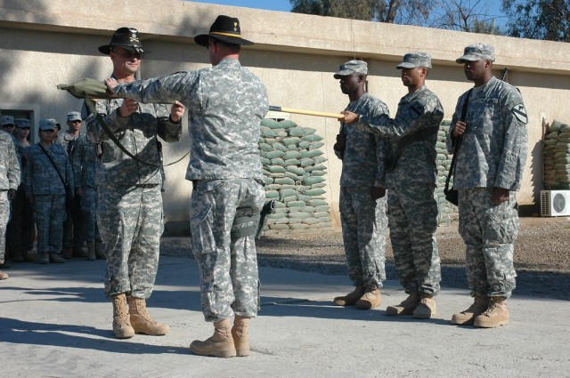 Lt. Col. Christopher Joslin, commander of 2nd "Lobo" Battalion, 227th Aviation Regiment, 1st Air Cavalry Brigade, 1st Cavalry Division, (left), and 1st Sgt. Terrance O'Neal, the acting battalion command sergeant major, (center), case the unit's...