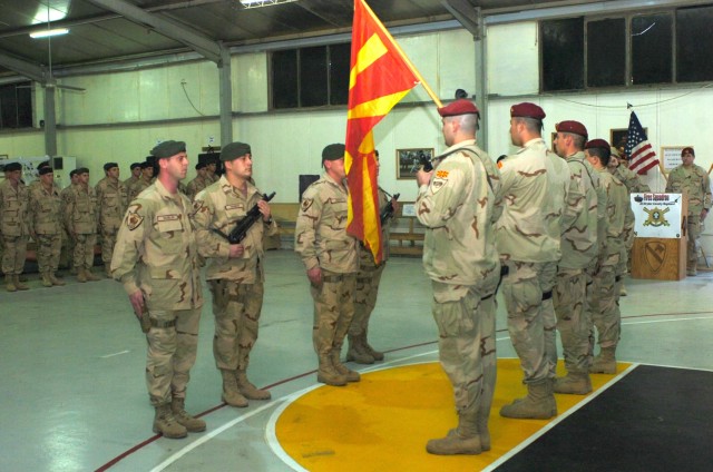 Macedonian Special Forces soldiers from the outgoing Macedonian "Wolves" Team Rotation 9 (right in red berets) prepare to hand the Macedonian national colors to the incoming Macedonian Rangers (left) of Macedonian Team Rotation 10 during a transfer o...
