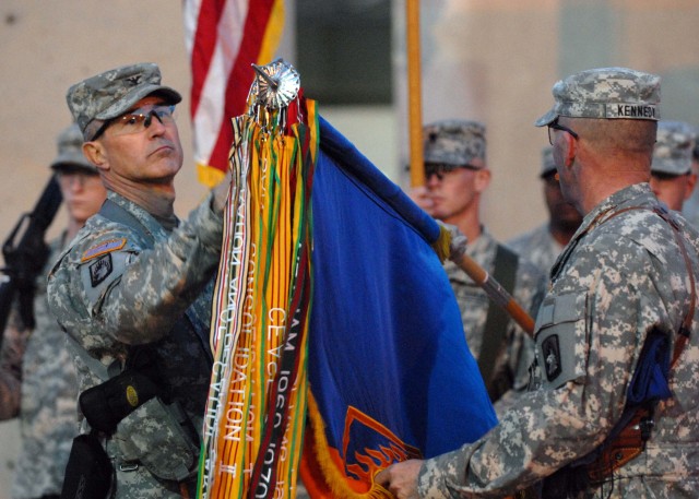 CAMP TAJI, Iraq - Task Force XII commander, Col. Timothy Edens (left) unfurls the brigade's colors during a TOA ceremony held Dec. 17.  The task force assumed the mission as the primary aviation asset for Multi-National Division-Baghdad at one...