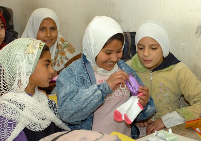 JERF AL MILA, Iraq -- After receiving items sent in packages to Iraq by U.S. students, Iraqi school girls look at the "goodies" a fellow class mate received at an elementary school in Jerf Al Mila, in northwest Baghdad ,Dec. 17. Iraqi troops from...