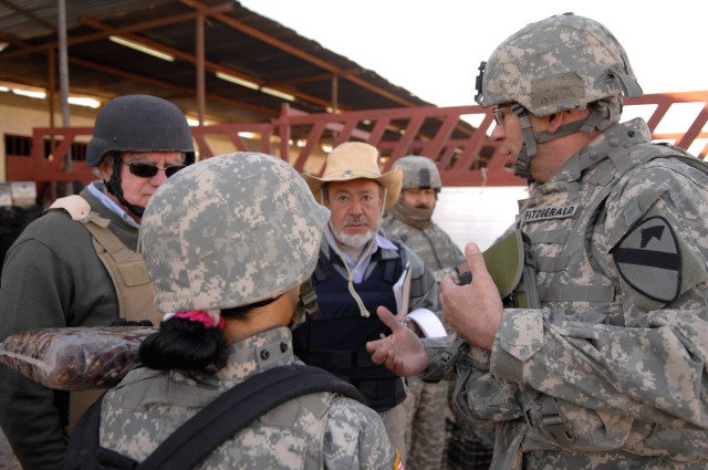 CAMP TAJI, Iraq -- Hermosa, S.D. native Lt. Col. Harvey Fitzgerald (right), senior agricultural business advisor for the 1st Brigade Combat Team, 1st Cavalry Division's Embedded Provincial Reconstruction Team, ePRT Baghdad-5, talks with members of th...