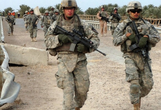 After talking to a local tribal sheik about reopening a bridge, Soldiers from Company A, 2nd 'Lancer' Battalion, 5th Cavalry Regiment and Headquarters Company, 2nd "Stallion" Battalion, 8th Cavalry Regiment walk past a bridge during a Dec. 18...