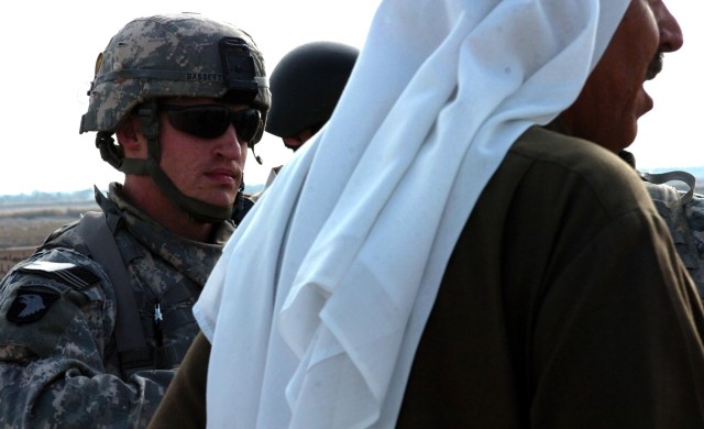 ABU OBAED, Iraq - During a patrol to examine a local bridge, Roseburg, Ore. native Capt. Brian Bassett (left), commander, Company A, 2nd 'Lancer' Battalion, 5th Cavalry Regiment speaks through an interpreter to a local area tribal sheik Dec. 18...