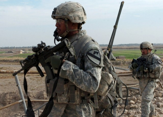 ABU OBAED, Iraq -- Soldiers from Company A, 2nd Battalion, 5th Cavalry Regiment, Clearwater, Fla. native Spc. Lennon Inoa (left), an infantryman, and Staff Sgt. Juan Vargas, a squad leader, who hails from Harlingen, Texas walk past a bridge near...