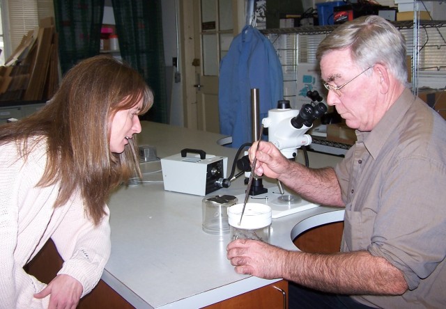 CHPPM entomologist Tom Harkins removes spider&#039;s egg case from web.