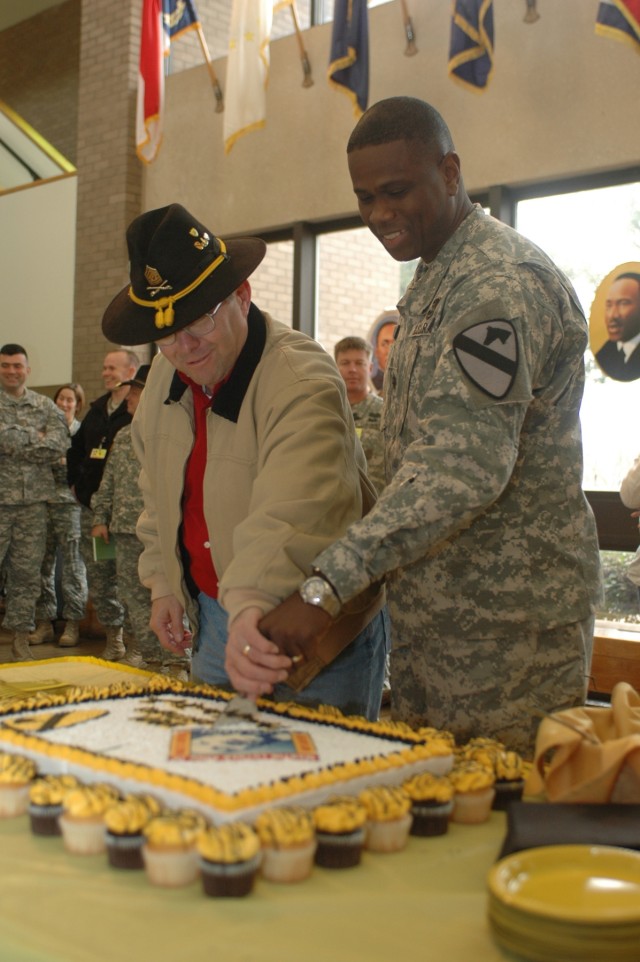 Lt. Col. Archie Davis, 1st Cavalry Division's rear detachment's deputy commander (left) cuts a cake in honor of Martin Luther King Jr., with the assistance of retired Command Sgt. Maj. Dennis Webster, a 1st Cavalry Division Association executive dire...