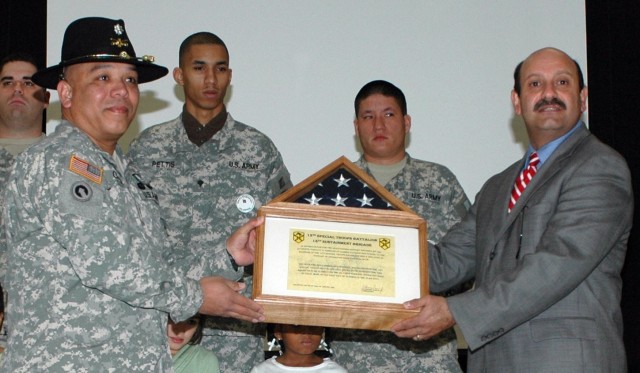 Lt. Col. Victoriano Garcia, the commander of 15th Special Troops Battalion, 15th Sustainment Brigade, presents Nabil Diab, the principal of Clarke Elementary School, with an United States of America flag Jan. 23, which flew over Camp Taji, Iraq in...