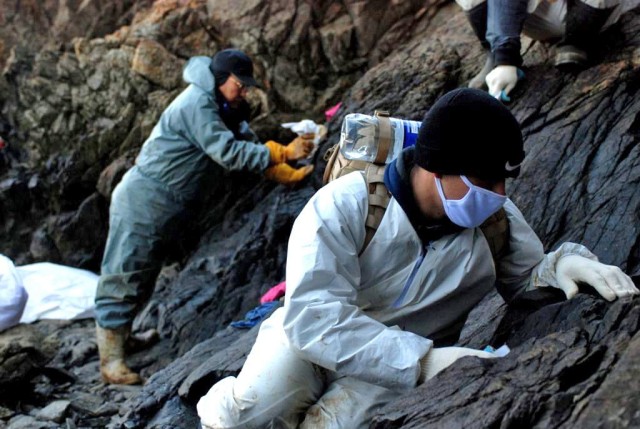 Soldiers Clean Oil from Rocks