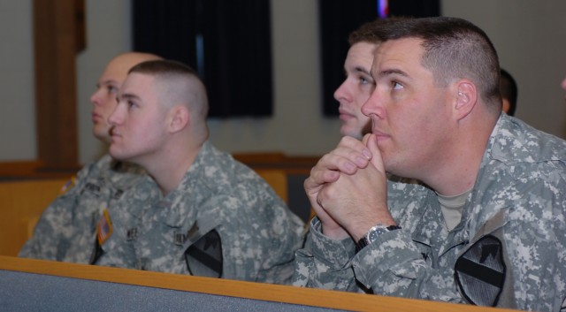 1st Cavalry Division Soldiers with the 4th "Guns" Battalion, 227th Aviation, 1st Air Cavalry Brigade watch photographic memories of Capt. Mark Resh and Chief Warrant Officer 3 Cornell Chao during a remembrance ceremony at West Fort Hood Chapel...