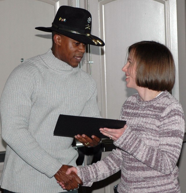 Lt. Col. Darrell Aubrey (left), officer in charge of support operations for 15th Sustainment Brigade, bids farewell to Lt. Col. Bonnie Hartstein (right), brigade surgeon for 15th SB, and presents her with a certificate.  Everyone leaving the brigade ...