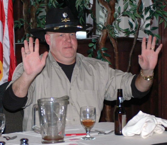 Lt. Col. Russell Cavin, 15th Sustainment Brigade's deputy commander, throws his hands up in a gesture to stop the laughing as someone in the crowd jokes about him.  Cavin was bid farewell at the dinner along with 16 other non-commissioned and commiss...