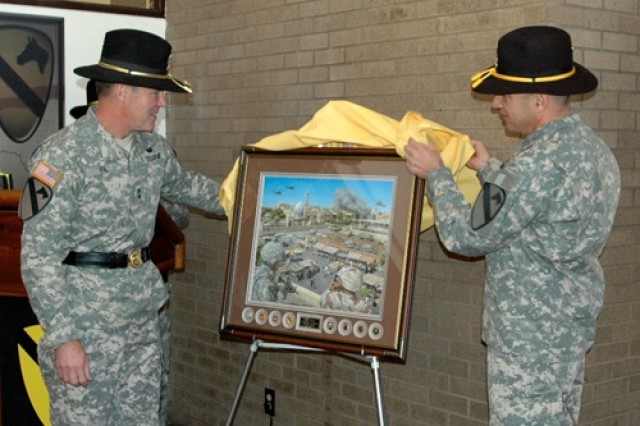 Maj. Gen. (P) Joseph F. Fil, Jr., 1st Cavalry Division's former commanding general (left), and his top noncommissioned officer, Command Sgt. Maj. Philip Johndrow, lift a cloth off of a print by Jody Harmon titled "The Surge" during an unveiling...