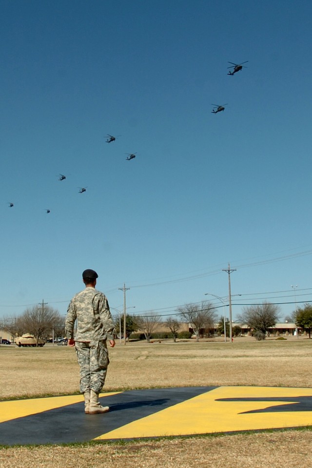 Lt. Col. Christopher Joslin, the commander of the 2nd Battalion, 227th Aviation Regiment, 1st Air Cavalry Brigade, 1st Cavalry Division, watches from the First Team's patch on Cooper Field as eight of his battalion's UH-60 Black Hawk helicopters fly ...