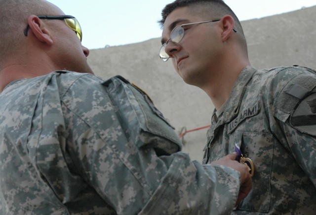 Pfc. Stephen Russell, an infantryman with "Bone" Company, 1st Squadron, 12th Combined Arms Battalion, 3rd Brigade Combat Team, 1st Cavalry Division, listens intently as Col. David W. Sutherland, commander of the "Grey Wolf" Brigade, talks to him...