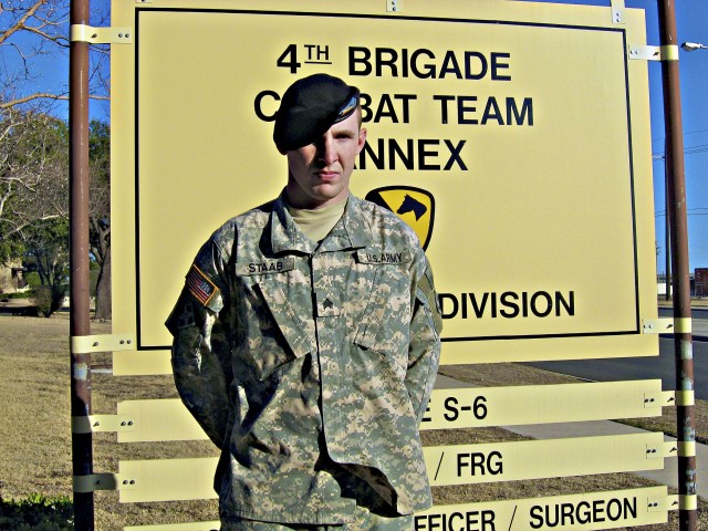 Sgt. Jonathan Staab, a field artilleryman assigned to Battery, B, 2nd Battalion, 77th Field Artillery Regiment, 4th Brigade Combat Team, 4th Infantry Division, the distinguished honor graduate from his Warrior Leader Course, stands by a sign denoting...