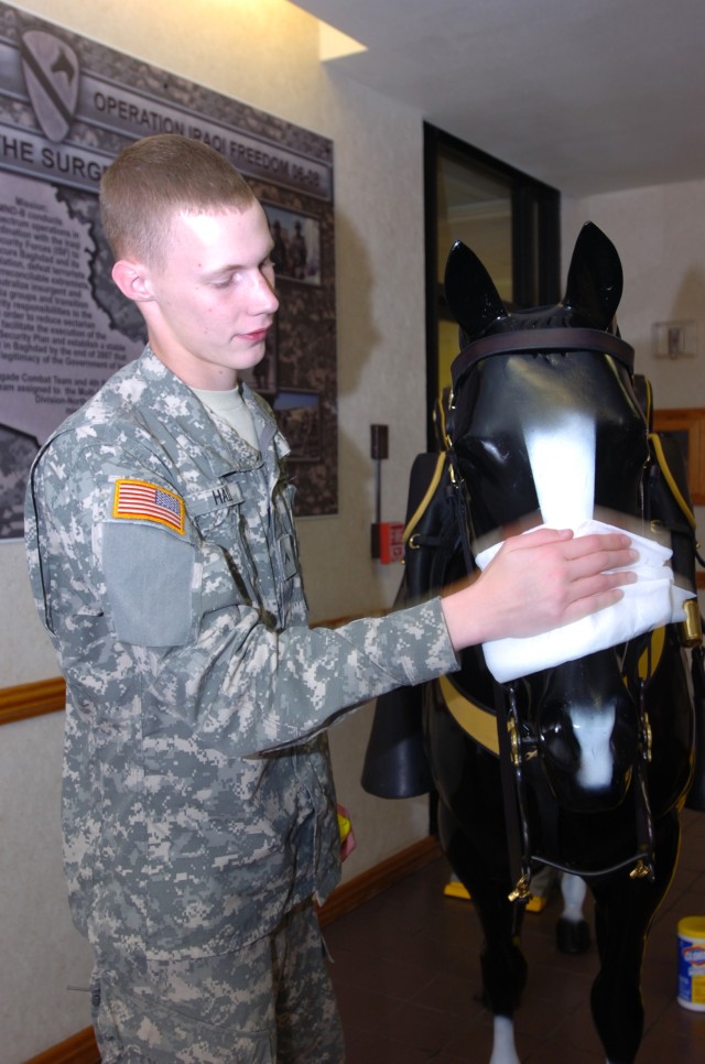 Pvt. James Hall, a native of Keller, Texas, and a human resource specialist with Headquarters and Headquarters Battery, 2nd Battalion, 82nd Field Artillery Regiment, 1st Cavalry Division, helps keep the new Trigger clean and shiny in the north foyer ...