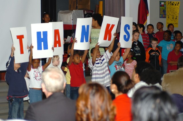 Second grade students from Trimmier Elementary School hold up placards spelling out "thanks" after singing a song for Soldiers of the 4th "Guns" Battalion, 227th Aviation Regiment, 1st Air Cavalry Brigade, 1st Cavalry Division, during a welcome...