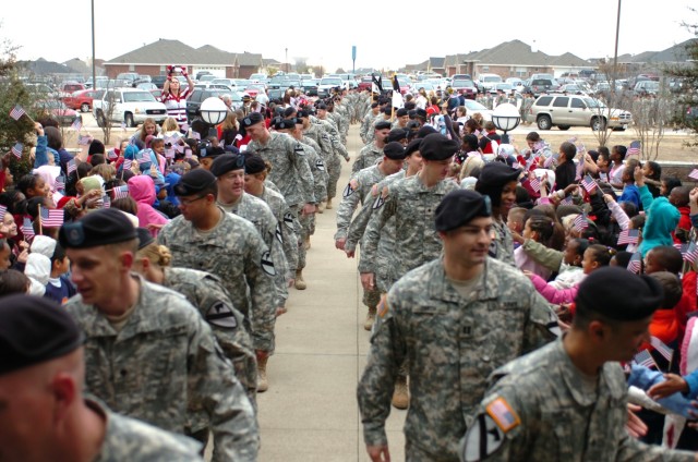 Soldiers from the 4th "Guns" Battalion, 227th Aviation Regiment, 1st Air Cavalry Brigade, 1st Cavalry Division, file through cheering students at Trimmier Elementary School during a welcome home ceremony Feb. 22. The students and faculty put on a...
