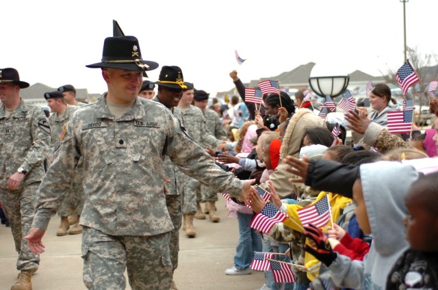 Orlando, Fla., native Lt. Col. Timothy DeVito, commander of the 4th "Guns" Battalion, 227th Aviation Regiment, 1st Air Cavalry Brigade, 1st Cavalry Division, gives high fives to students of Trimmier Elementary School as he and his Soldiers walk...