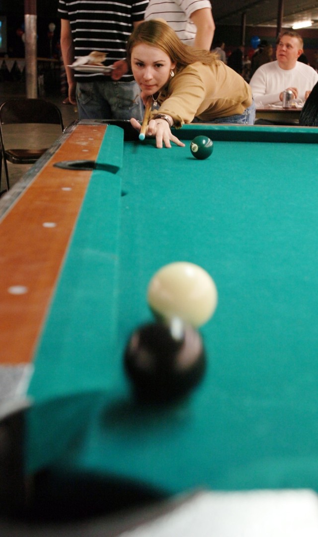 Pfc. Ashley Taylor, Headquarters and Headquarters Company, 3rd Brigade Special Troops Battalion, 3rd Brigade Combat Team, 1st Cavalry Division, and a native of Timoanook, Ore., sinks the "8-ball," winning her pool game during the battalion social, Fe...