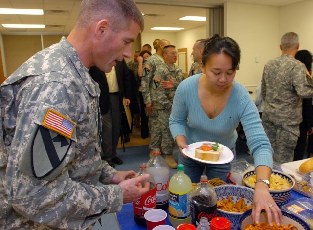 Lt. Col. Michael Rose, commander of 3rd Brigade Special Troops Battalion, 3rd Brigade Combat Team, 1st Cavalry Division, pours drinks for an award winner during the 3rd BSTB Family Readiness Group award ceremony Feb 21.  The ceremony was to...