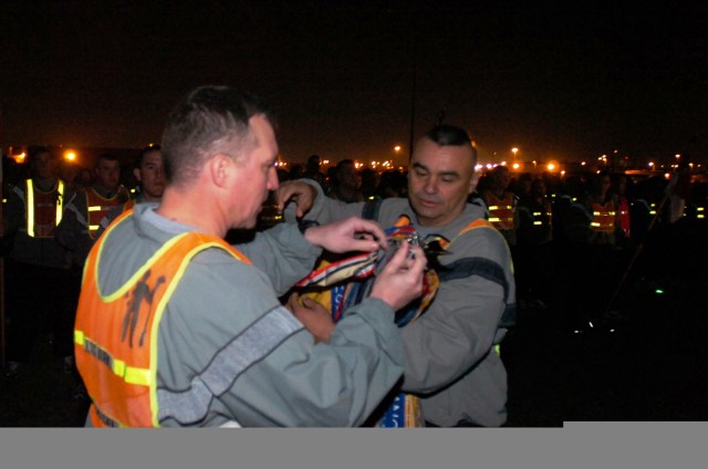 Lt. Col. Dale Kuehl, commander of the 1st Battalion. 5th Cavalry Regiment and Command Sgt. Major Fidel Gomez, 1-5 Cav.'s top enlisted Solider, affix an Iraqi campaign streamer to their battalion's guideon before the 2nd Brigade Combat Team, 1st Caval...