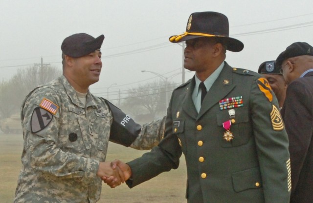 Sgt. 1st Class Kevin Patterson of Hyattsville, Md., a protocol officer in charge with Company A, Division Special Troops Battalion, 1st Cavalry Division, congratulates Sgt. Maj. Larry Warren, the division's former G6 senior noncommissioned...