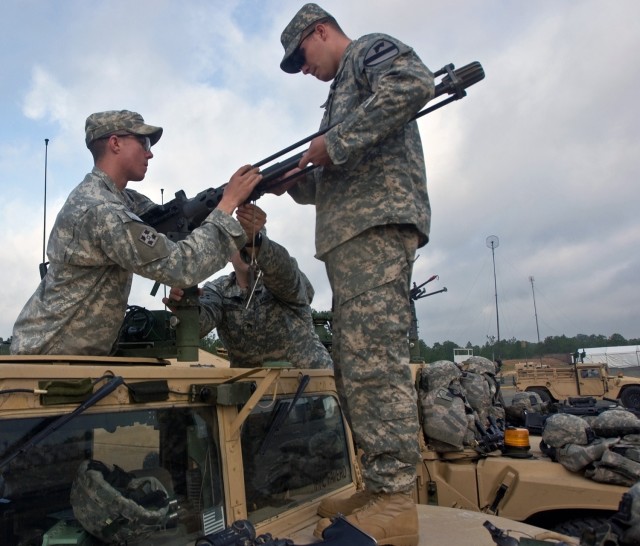 Sgt. Blake Brandenburg, Sgt. Steve Robinson and Spc. David Williams, forward observers assigned to the 4th Brigade Combat Team's personal security detachment install a .50 caliber machine gun to a vehicle. The 1st Cavalry Division's new Long Knife...