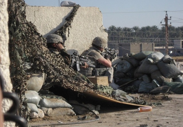 While under enemy fire, Garnett, S.C. native Sgt. 1st Class Freddie Housey (left), platoon sergeant, Company D, 2nd Battalion, 8th Cavalry Regiment, 1st Brigade Combat Team, 1st Cavalry Division calls in an initial attack report as another Soldier...
