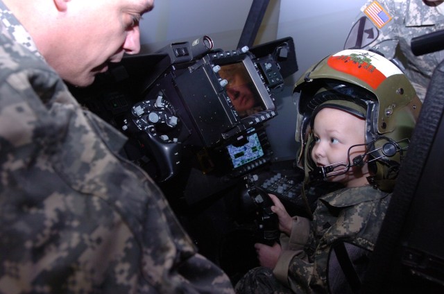 Honorary Staff Sgt. Gaven Cox maneuvers a virtual Apache helicopter on Fort Hood, Texas, March 20. After successfully completing the training he was deemed an honorary gun pilot. As part of the Make-a-Wish Foundation, Cox's wish to become a...