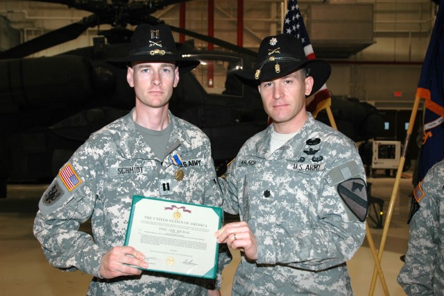 Las Vegas native Lt. Col. Christopher Walach (right), commander of the 1st "Attack" Battalion, 227th Aviation Regiment, 1st Air Cavalry Brigade, 1st Cavalry Division, presents Capt. Nathan Schmidt (left), commander of Company C, 1-227th, with an...