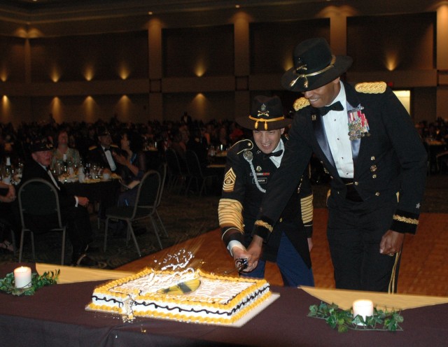Brig. Gen. (P) Vincent K. Brooks (right), the commanding general of the 1st Cavalry Division from Alexandria, Va., cuts the cake at the division's military ball with the help of his top noncommissioned officer, Command Sgt. Maj. Philip Johndrow from ...