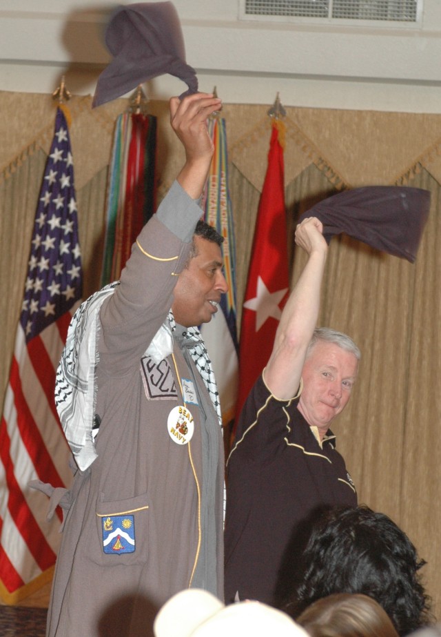 Brig. Gen. (P) Vincent K. Brooks, the commanding general of the 1st Cavalry Division, and Brig. Gen. Patrick Finnegan, the dean of the U.S. Military Academy, West Point, wave their napkins to a rousing tune during a founder's day celebration at...
