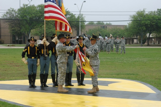 Col. Dan Shanahan, commander of the 1st Air Cavalry "Warrior" Brigade, 1st Cavalry Division, left, and Command Sgt. Maj. Scott Spiva, the brigade's top noncommissioned officer, right, attach a streamer to the brigade guidon during a change of...