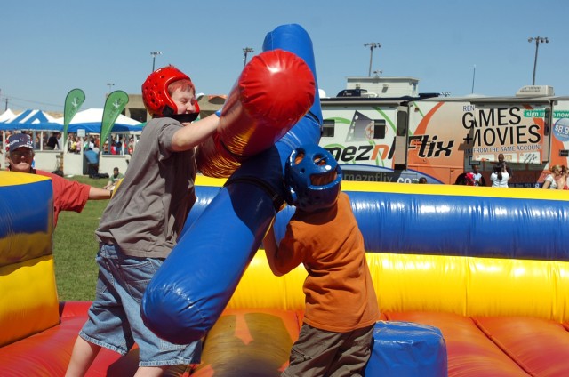 Two young men enjoy a little roughhousing during III Corps "Salute to our Soldiers" day at the Fort Hood Stadium April 11. Thousands attended to see live entertainment, play games and have fun during the all-day event geared toward thanking troops...