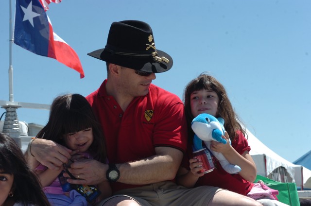 Santa Fe, N.M., native Maj. John Garcia, information operations officer for the 1st Brigade Combat Team, 1st Cavalry Division spends some time with his daughters, Veronica, 4, (left) and Teresa, 7, (right) as they listen to singer Jennifer Pena durin...