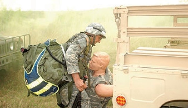 Spc. Daniel Farrier, Medical Command&#039;s Soldier of the Year, removes a mannequin simulating a casualty from a vehicle during the combat scenario part of the MEDCOM Best Warrior Co