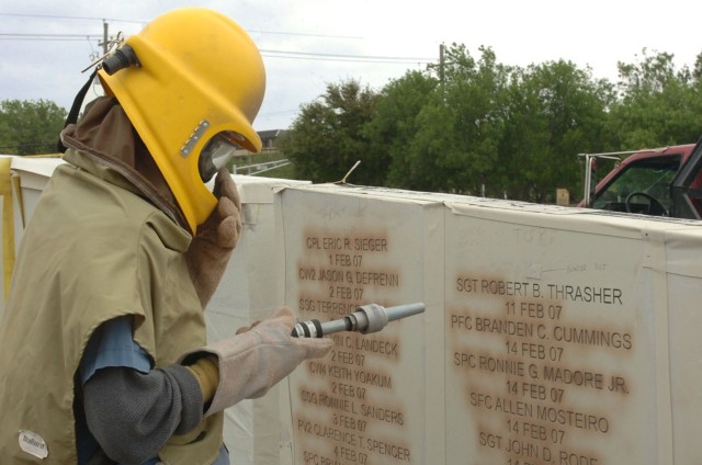 Wayne Smith, the shop foreman of the Waco, Texas-based monument business Phipps Memorial, etches out the name of Sgt. Robert B. Thrasher at the Fort Hood's Operation Iraqi Freedom memorial located in front of the 1st Cavalry Division's headquarters b...